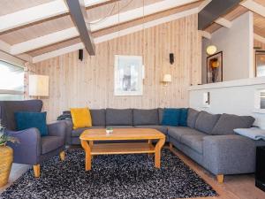 9 person holiday home in Ringk bing في سوندرفيغ: غرفة معيشة مع أريكة وطاولة قهوة