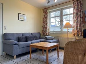 een woonkamer met een blauwe bank en een tafel bij Parkstrasse -Whg1 in Wyk auf Föhr