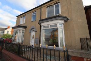 a house with a fence in front of it at Dinnington House in Dinnington