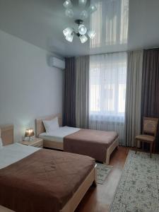 Апарт отель Welcome في تالديكورغان: غرفة نوم بسريرين ومروحة سقف