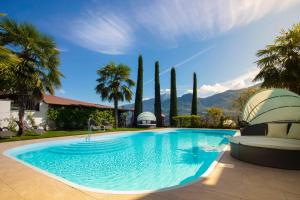 una piscina en un patio con palmeras en Residence Untermösslhof, en Lana