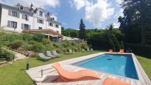 a swimming pool in the yard of a house at Hôtel Restaurant Le Repère in Vizille