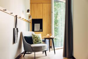 a living room with a chair and a window at harry's home hotel & apartments in Berlin