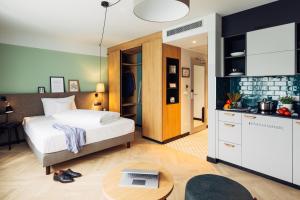 a bedroom with a bed and a kitchen with a table at harry's home hotel & apartments in Berlin