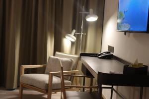 a room with two chairs and a desk with a phone at The Brunei Hotel in Bandar Seri Begawan