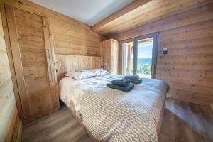 a bedroom with a bed with two towels on it at Chalet 14p vue lac, spa et sauna in Gérardmer