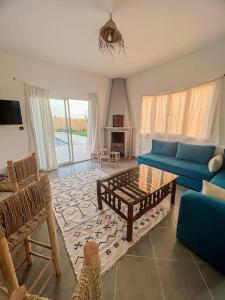 ein Wohnzimmer mit einem blauen Sofa und einem Tisch in der Unterkunft Oasis Villa Essaouira in Essaouira