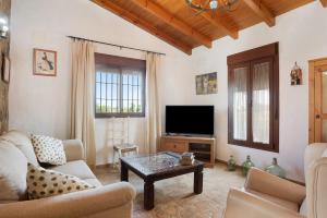 ein Wohnzimmer mit einem Sofa und einem TV in der Unterkunft Casa Nazaret in Conil de la Frontera