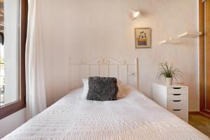 ein Schlafzimmer mit einem weißen Bett und einem Kissen darauf in der Unterkunft Casa Nazaret in Conil de la Frontera