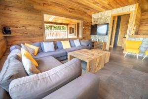 a living room with a couch and a table in a cabin at Chalet 14p vue lac, spa et sauna in Gérardmer