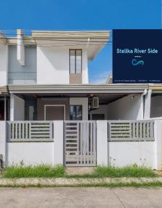 a white house with a sign in front of it at Stellka cheerful 2BR townhouse near the beach and city in Nasugbu