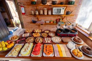uma mesa com vários tipos diferentes de pastelarias em Pousada 3 Pinheiros em Campos do Jordão