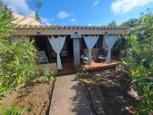 a house with white curtains and a patio at Villa cesar in Costa Paradiso