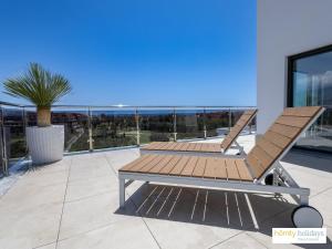 un banco de madera en la parte superior de un patio en Homity Exclusive Playa Granada Beach & Golf - Aguacate Beach, en Motril