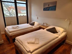 2 camas individuais num quarto com uma janela em Rothtraut Remise Whg4 em Wyk auf Föhr