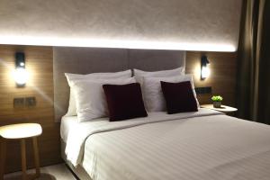 a bedroom with a large white bed with two pillows at The Brunei Hotel in Bandar Seri Begawan