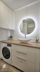 een witte badkamer met een wastafel en een spiegel bij Roissy, CDG, Paris, Disney, Astérix in Gonesse