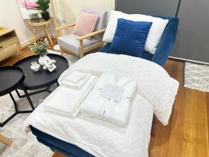 a bedroom with a white bed and a blue chair at Footscray home just 7km away to Melbourne CBD newly stylist setup in Melbourne