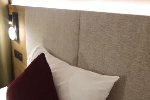 a headboard of a bed with a red and white pillow at The Brunei Hotel in Bandar Seri Begawan