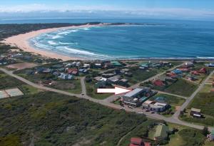 an aerial view of a beach with houses and the ocean at Casual, beachy and 100m to Seals Surf Spot in Cape St Francis