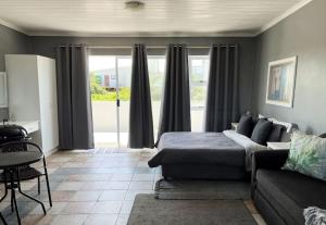 un soggiorno con un letto e un divano di Casual, beachy and 100m to Seals Surf Spot a Cape St Francis Altre 14 foto