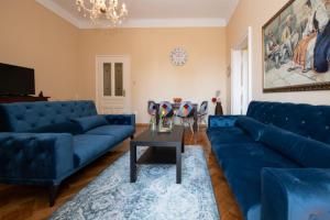 uma sala de estar com sofás azuis e uma mesa em Apartman Zobec Jambrusic em Opatija