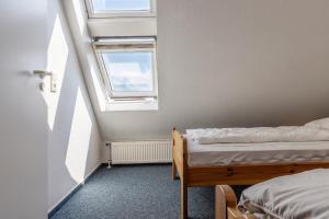um pequeno quarto com 2 camas e uma janela em Ferienhaus 50009 em Carolinensiel