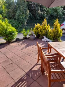 a patio with a wooden table and chairs and plants at Ferienwohnung Pickel in Kottenheim
