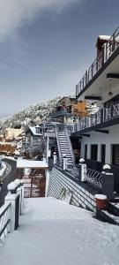 ein Gebäude mit Schnee auf dem Boden und Treppen in der Unterkunft Jai Anjana Resort in Kanatal