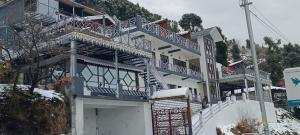ein Gebäude mit blauen und weißen Balkonen darüber in der Unterkunft Jai Anjana Resort in Kanatal