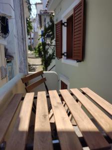 una mesa de picnic de madera frente a un edificio en VILLA ELLIS SKIATHOS en Skíathos