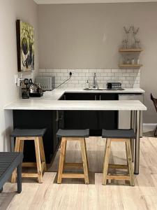 a kitchen with a counter and a sink and two stools at Metanoia Kingswood Golf Estate in George