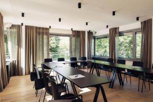 harry's home hotel & apartments في برلين: قاعة المؤتمرات مع الطاولات والكراسي والنوافذ
