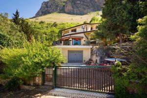 a house with a gate in front of a mountain at Villa Stefania in Castellammare del Golfo