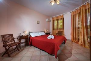 1 dormitorio con 1 cama con colcha roja en Villa Stefania, en Castellammare del Golfo