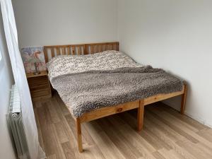 Bett in einem Schlafzimmer mit Holzboden in der Unterkunft Wagończyk in Grzegrzółki