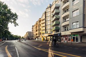 a person riding a bike down a city street at harry's home hotel & apartments in Berlin