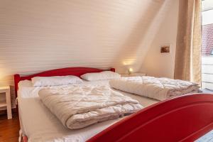 two beds in a bedroom with a red headboard at 50171 Haus Antje I in Harlesiel