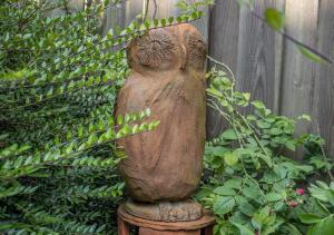 a statue of an owl sitting on a stump at 50172 Haus Antje II in Harlesiel