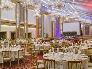 a banquet hall with tables and chairs and chandeliers at Karachi Marriott Hotel in Karachi