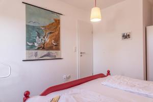 a bedroom with a bed with a painting on the wall at 50172 Haus Antje II in Harlesiel
