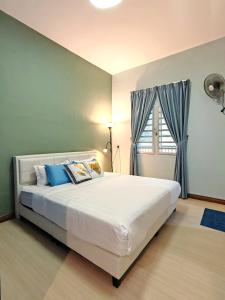 Un dormitorio con una gran cama blanca y una ventana en W13 atGoldenHills NightMarket WiFi 4R, en Brinchang