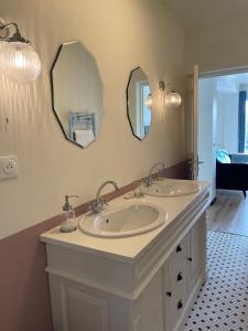 a bathroom with two sinks and two mirrors at Ambiance Seine, appartement surplombant la Seine -51 M2, Anémone- in Thomery