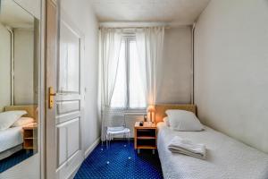 Cette petite chambre comprend 2 lits et une fenêtre. dans l'établissement Hôtel VAL FLORES LOGIS, à Biarritz
