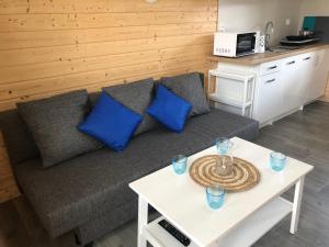 a living room with a couch and a table with blue pillows at Domki Wypoczynkowe "Sea Breeze" in Rewal