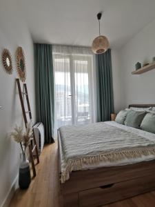 1 dormitorio con 1 cama con cortinas verdes y ventana en Beach Pearl, en Bečići