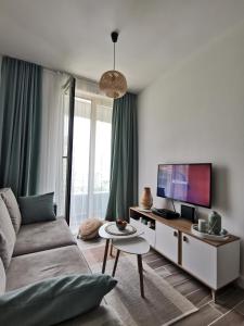 a living room with a couch and a tv at Beach Pearl in Bečići