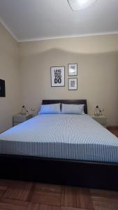 1 dormitorio con 1 cama grande con rayas azules y blancas en Terrazza Porta Venezia HOWME en Milán