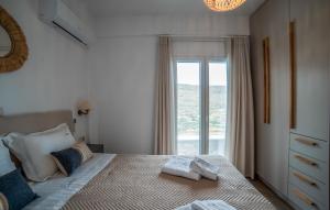 a bedroom with a bed with a large window at Epithea Suites Kythnos 3 με ιδιωτική πισίνα in Kithnos +30 photos