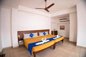 a bedroom with a bed with a blue and yellow comforter at VKG Hotels in Puducherry